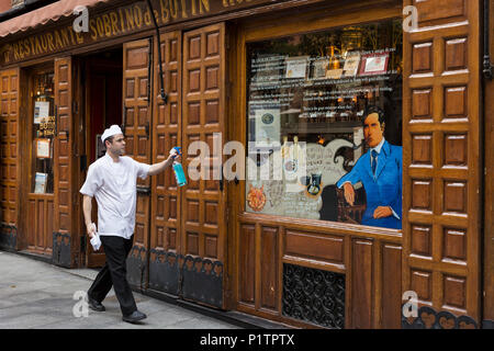 Madrid, Spain: A worker cleans the front window of Restaurante Sobrino de Botín. Originally founded in 1725 as Casa Botín, it is known as the oldest c Stock Photo
