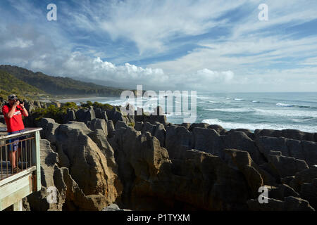 Tourist and Pancake Rocks, Punakaiki, Paparoa National Park, West Coast, South Island, New Zealand Stock Photo