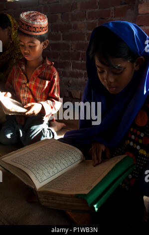 Students reading the Holy Quran at a maktab. Maktab an Arabic word meaning schools for teaching children in elementary Islamic subjects. Dhaka, Bangla Stock Photo