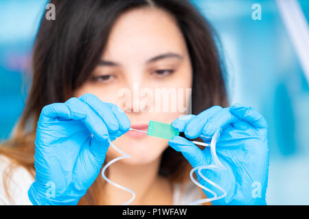 technician girl with microfluidic device LOC in microbiological lab Stock Photo