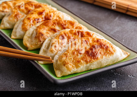 Plate of asian gyoza, dumplings snack with soy sauce.