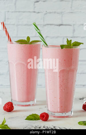 Raspberry milkshake with mint and drinking straws. Stock Photo