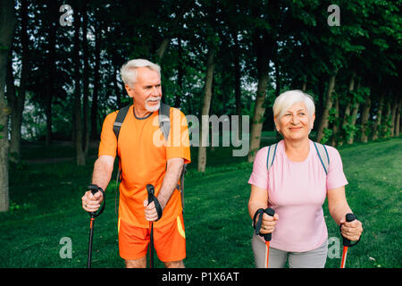 Senior couple hiking below trees, active lifestyles Stock Photo