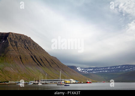 Boats at dock in Isafjordur below Kirkjubolsfjall mountain, West Iceland, Iceland Stock Photo