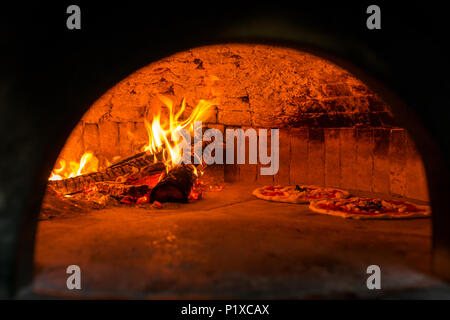 Original neapolitan pizza margherita in a traditional wood oven in Naples restaurant, Italy Stock Photo