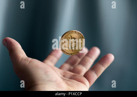 golden coins bitcoin falling into the hands Stock Photo
