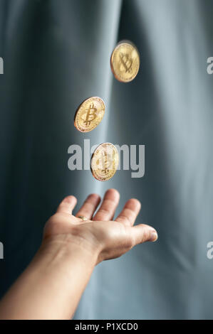 golden coins bitcoin falling into the hands Stock Photo
