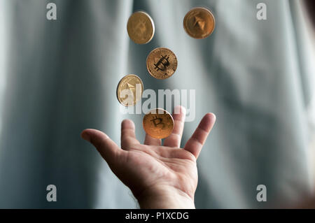 golden coins bitcoin falling into the hands Stock Photo