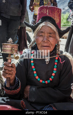 Lamayuru, India - June 19, 2017: Unidentified ladakhi old lady with the tibetan prayer wheel during buddhist festival in Lamayuru Gompa monastery, Lad Stock Photo