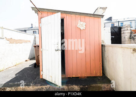 Exterior of an old abandoned pink shed with white door in a northern England back yard. Stock Photo