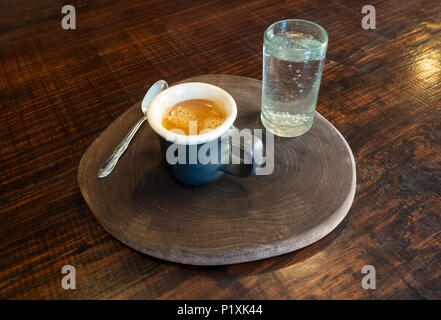 A cup of espresso coffee with a small glass of sparkling water Stock Photo