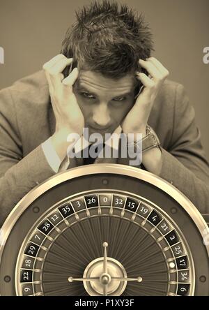 Stressed Gambling addict and casino roulette Stock Photo