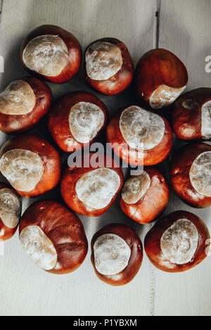 Ripe chestnuts on old wooden table and sack napkin close up with copy space. Stock Photo