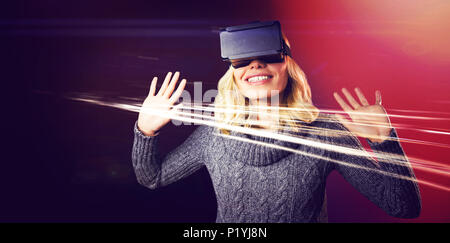 Cheerful young woman using reality virtual headset Stock Photo