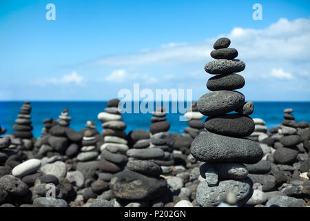 Stones pyramids on pebble beach in Tenerife, Canary Islands, Spain. Concept of harmony and balance Stock Photo