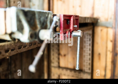 Old vices attached to a homemade workbench in an abandoned shed Stock Photo
