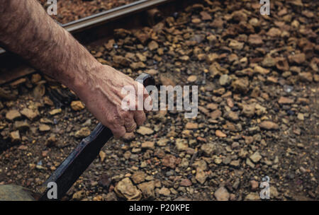 Hand with gold ring grabbing the lever to change via ferrea in the old train station of Zaranda, Spain Stock Photo