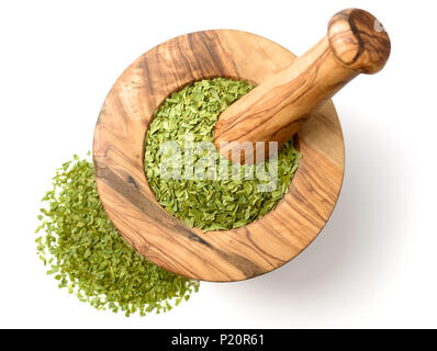 dried tarragon leaves in the wooden mortar, isolated on white Stock Photo
