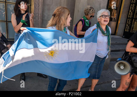 Barcelona, Spain. 13th June 2018. A woman is seen showing the flag of Argentina in solidarity with Argentine women. Argentina is discussing a future law on the regulation of abortion at the congress today. So a group of women have concentrated with their green handkerchiefs in solidarity with the Argentine women at the door of the consulate of Argentina in Barcelona. Stock Photo