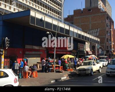 FILED - 24 January 2015, South Africa, Johannesburg: People sit at a busy street crossing in Hillbrow, one of Johannesburg's most dangerous districts. South Africa's economic metropolis is known as one of the most dangerous cities in the country. Now, the metropolis wants to improve its image. Photo: Jürgen Bätz/dpa Stock Photo