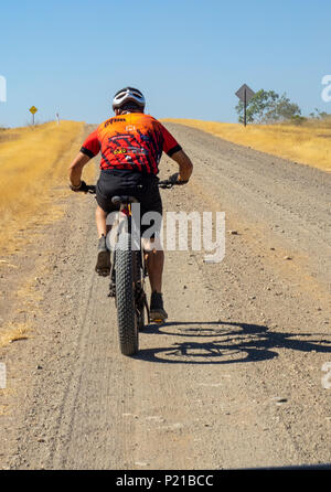 Gibb Challenge 2018 a cyclist in Jersey and bib riding a fatbike on dirt road Gibb River Road Kimberley Australia Stock Photo