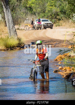 Gibb Challenge 2018 a cyclist on a mountain bike crossing the Pentecost River at El Questro Station Kimberley Australia Stock Photo