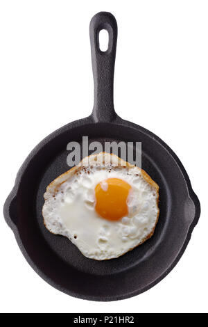 Food: single fried egg on a black ironcast frying pan, isolated on white background Stock Photo