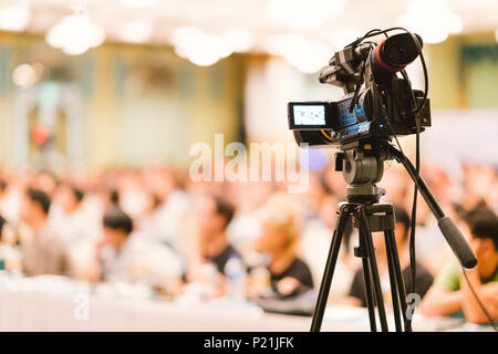 Video camera set record audience in conference hall seminar event. Company meeting, exhibition convention center, corporate announcement concept Stock Photo