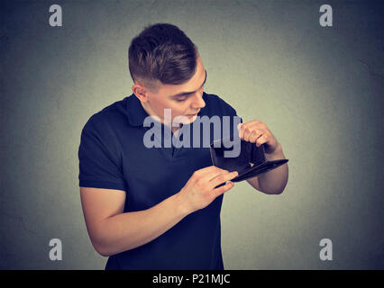 Upset man holding empty wallet Stock Photo