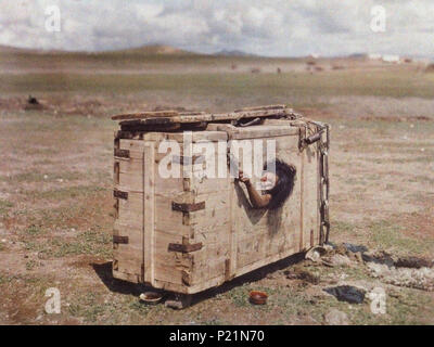 . English: A Mongolian woman reaches out from the porthole of a crate in which she is imprisoned. c. July 1913 [1][2]. Stéphane Passet (1875-after 1930), on behalf of Albert Kahn (1860-1940) 195 Mongolian woman condemned to die of starvation (retouched) Stock Photo