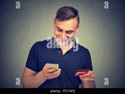 Man using mobile phone making online payment with his credit card Stock Photo