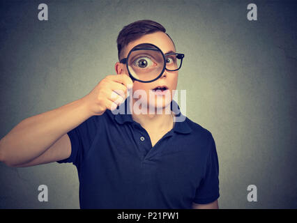 Curious man looking through a magnifying glass Stock Photo