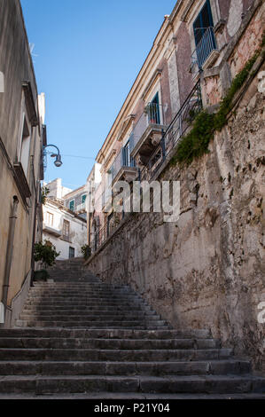 A view of a typical Sicilian road with a stairway in the baroque city of Modica, Sicily, Italy. Unesco heritage site. Stock Photo