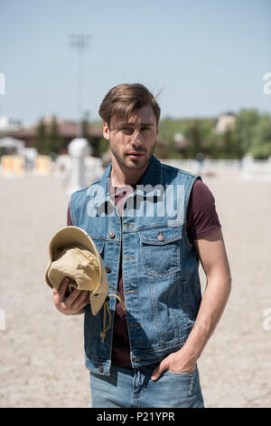 Young handsome man wearing denim shirt standing over isolated white ...