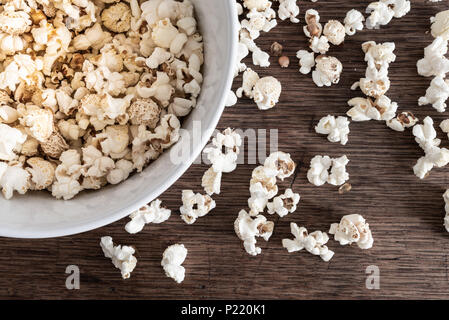 directly above close-up of bowl filled with popcorn on rustic wooden table Stock Photo