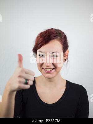 A young girl shows facial expressions that the job is done well, white background, studio, facial expressions Stock Photo