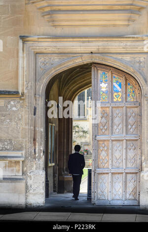 A student enters via the front door of Oriel college at the university of Oxford, England. Stock Photo