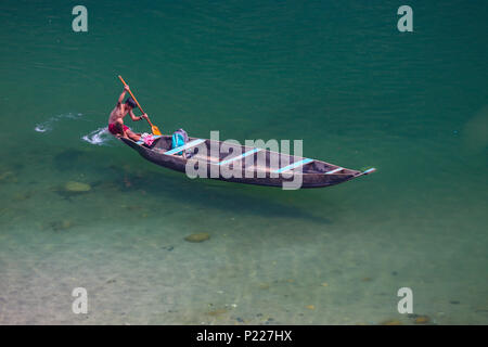 A Local Boy Rows the Boat in Umngot River at Dawki (Meghalaya) Stock Photo