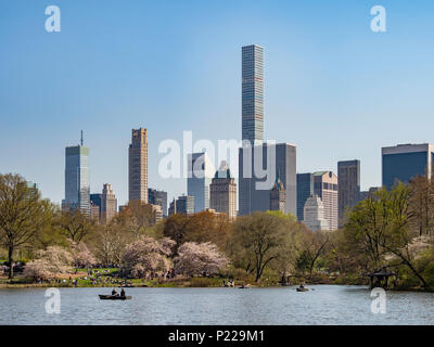 Rowing boats on The Pond in Central Park with trees, skyscrapers and the Manhattan skyline in the background, New York, USA Stock Photo