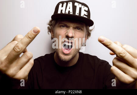 Angry hater shouting and showing his middle fingers Stock Photo
