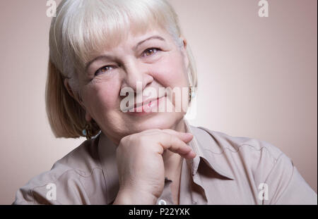 Headshot portrait of an amiable elderly woman smiling in a studio Stock Photo
