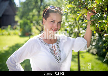 Beautiful young woman in an orchard on countryside Stock Photo