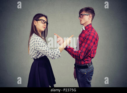 Annoyed angry man and woman facing relationships problems, pointing fingers each other blaming for mistakes. Couple in disagreement having argument, c Stock Photo