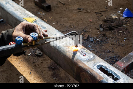 Metal work. Man cuts a hole in a steel piece using gas welding Stock Photo