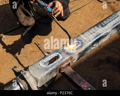 Metal work. Man cuts a hole in a steel piece using gas welding Stock Photo