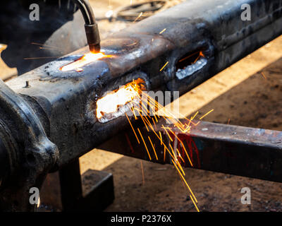 Metal work. Man cuts a hole in a steel piece using gas welding Stock Photo