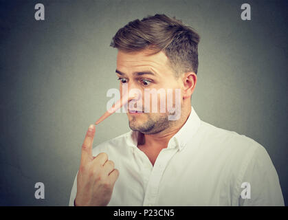 Worried shocked man with long nose. Liar concept. Stock Photo