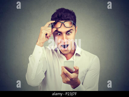 Shocked man looking reading news on smart phone Stock Photo