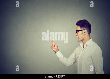 Cheerful handsome man showing direction and pointing with finger Stock Photo