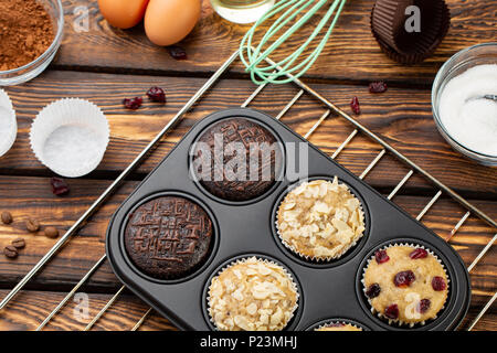 The process of making muffins in bright silicone forms. Cooking process. Preparation stage. Ingredients and ready-made different cupcakes Stock Photo
